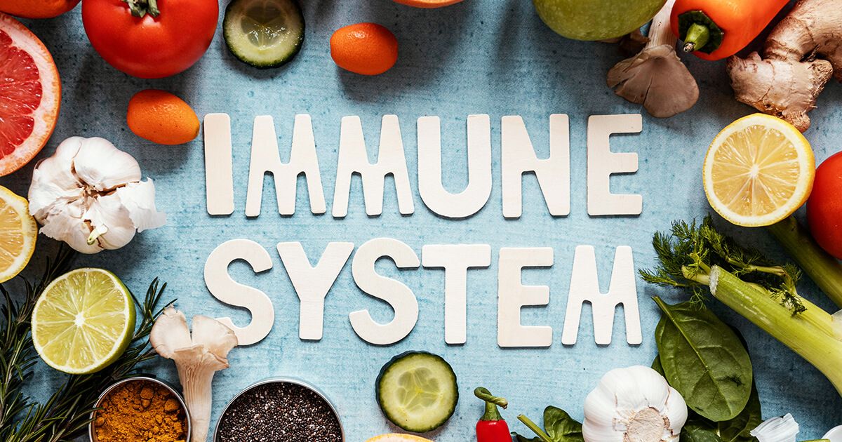 Fruits and vegetables surrounding paper cut letter 'Immune System'