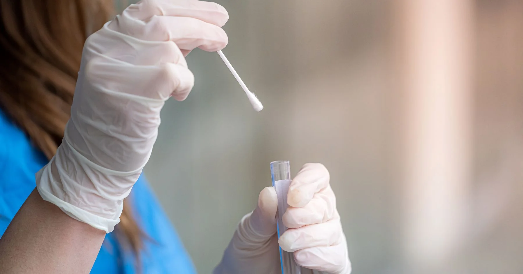 Medical swab sample being placed in test tube