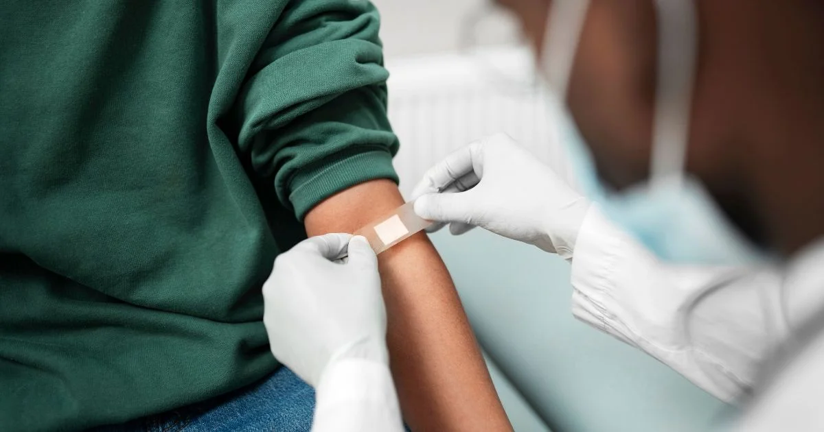 Healthcare worker applying bandage after blood test
