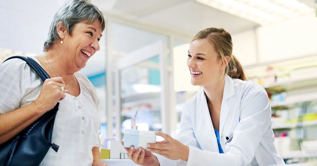 Pharmacist handing prescription box to customer