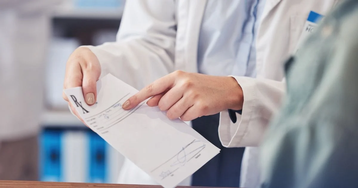 Pharmacist explaining prescription to patient at counter